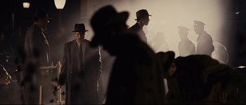 Movie still from “The Black Dahlia” (2006), directed by Brian De Palma – A group of men standing next to each other in the dark; Wide shot, Over the shoulder angle