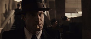 Movie still from “The Black Dahlia” (2006), directed by Brian De Palma – A person wearing a hat and smoking a cigarette; Close Up shot, Low angle