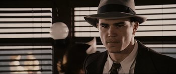 Movie still from “The Black Dahlia” (2006), directed by Brian De Palma – A man wearing a hat and a tie; Close Up shot, Over the shoulder angle