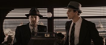Movie still from “The Black Dahlia” (2006), directed by Brian De Palma – Two men in suits and hats in front of a window; Medium shot, Low angle