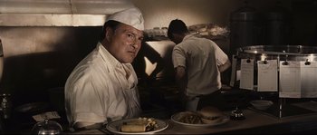Movie still from “The Black Dahlia” (2006), directed by Brian De Palma – A man sitting in front of a plate of food; Medium shot, Low angle