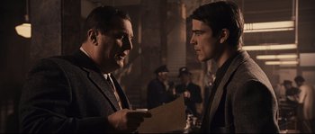 Movie still from “The Black Dahlia” (2006), directed by Brian De Palma – Two men in suits talking to each other in a dimly - lit room; Medium shot, Over the shoulder angle