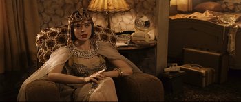 Movie still from “The Black Dahlia” (2006), directed by Brian De Palma – A woman sitting on a couch wearing a crown; Medium shot, Over the shoulder angle