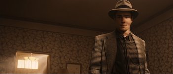 Movie still from “The Black Dahlia” (2006), directed by Brian De Palma – A man in a suit and hat standing in a room; Medium shot, Low angle