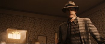 Movie still from “The Black Dahlia” (2006), directed by Brian De Palma – A man in a hat and a suit standing in a room; Medium shot, Low angle