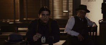 Movie still from “The Black Dahlia” (2006), directed by Brian De Palma – A man sitting at a table holding a cup; Medium shot, Over the shoulder angle