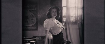 Movie still from “The Black Dahlia” (2006), directed by Brian De Palma – A woman standing in front of a window in a room; Medium shot, Low angle