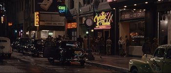 Movie still from “The Black Dahlia” (2006), directed by Brian De Palma – A car parked on the side of the road in front of a restaurant; Wide shot, High angle