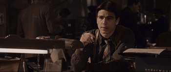 Movie still from “The Black Dahlia” (2006), directed by Brian De Palma – A man smoking a cigarette while sitting at a table; Close Up shot, Low angle