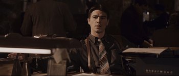Movie still from “The Black Dahlia” (2006), directed by Brian De Palma – A young man wearing a tie sitting at a table; Medium shot, Over the shoulder angle