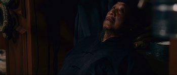 Movie still from “The Black Dahlia” (2006), directed by Brian De Palma – An older man with long black hair wearing a black shirt; Close Up shot, Low angle