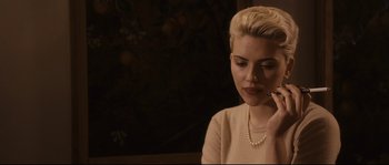 Movie still from “The Black Dahlia” (2006), directed by Brian De Palma – A woman with a pearl necklace is sitting in a room; Close Up shot, Over the shoulder angle