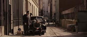 Movie still from “The Black Dahlia” (2006), directed by Brian De Palma – Two men standing next to an old car on the side of the street; Wide shot, High angle
