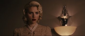 Movie still from “The Black Dahlia” (2006), directed by Brian De Palma – A woman with blonde hair wearing a beige dress; Close Up shot, Over the shoulder angle