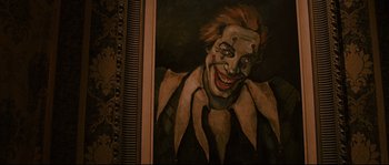 Movie still from “The Black Dahlia” (2006), directed by Brian De Palma – A painting of a clown smiling for the camera; Close Up shot, High angle