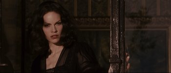 Movie still from “The Black Dahlia” (2006), directed by Brian De Palma – A woman in a black dress is posing for a picture; Close Up shot, Over the shoulder angle