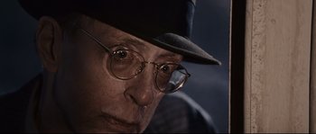 Movie still from “The Black Dahlia” (2006), directed by Brian De Palma – An older man wearing glasses and a hat; Close Up shot, Low angle