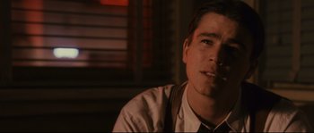 Movie still from “The Black Dahlia” (2006), directed by Brian De Palma – A man sitting in front of a window with a cigarette in his mouth; Close Up shot, Over the shoulder angle