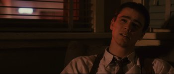 Movie still from “The Black Dahlia” (2006), directed by Brian De Palma – A man sitting in front of a window wearing a tie; Close Up shot, Over the shoulder angle
