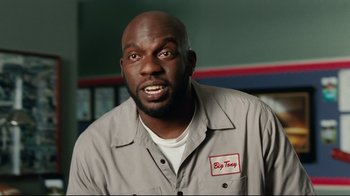 Movie still from “The Blind Side” (2009), directed by John Lee Hancock – A man with a big tooey logo on his shirt; Medium shot, Low angle