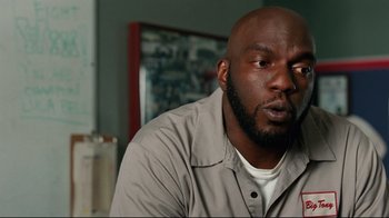 Movie still from “The Blind Side” (2009), directed by John Lee Hancock – A man in a gray shirt is sitting down; Close Up shot, Low angle