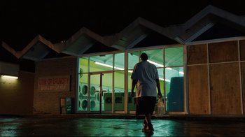 Movie still from “The Blind Side” (2009), directed by John Lee Hancock – A person walking in front of a building at night; Extreme Wide shot, Low angle