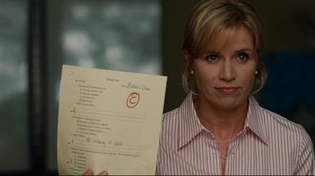 Movie still from “The Blind Side” (2009), directed by John Lee Hancock – A woman holding a piece of paper in front of her face; Close Up shot, Over the shoulder angle