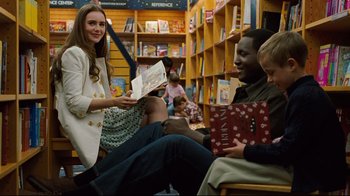Movie still from “The Blind Side” (2009), directed by John Lee Hancock – A woman is holding a book in her hands; Medium shot, Low angle