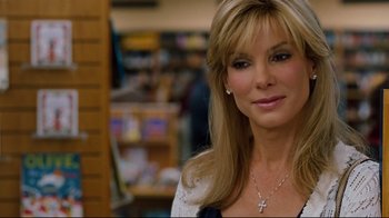 Movie still from “The Blind Side” (2009), directed by John Lee Hancock – A beautiful woman with long blonde hair wearing a necklace; Close Up shot, Over the shoulder angle