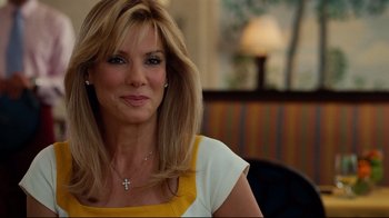 Movie still from “The Blind Side” (2009), directed by John Lee Hancock – A beautiful woman with a cross on her neck; Close Up shot, Over the shoulder angle