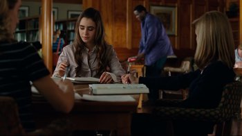 Movie still from “The Blind Side” (2009), directed by John Lee Hancock – A woman sitting at a table writing on a piece of paper; Medium shot, Over the shoulder angle