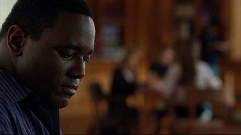 Movie still from “The Blind Side” (2009), directed by John Lee Hancock – A man's face in front of a group of people; Close Up shot, Over the shoulder angle
