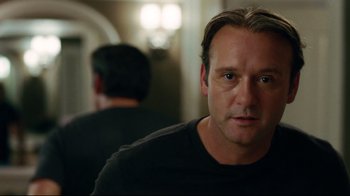 Movie still from “The Blind Side” (2009), directed by John Lee Hancock – A person wearing a black t - shirt; Close Up shot, Over the shoulder angle