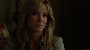 Movie still from “The Blind Side” (2009), directed by John Lee Hancock – A woman with long blonde hair sitting in a dark room; Close Up shot, Over the shoulder angle