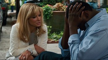 Movie still from “The Blind Side” (2009), directed by John Lee Hancock – A woman sitting next to a man on the ground; Close Up shot, Over the shoulder angle