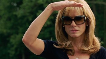 Movie still from “The Blind Side” (2009), directed by John Lee Hancock – A person wearing sunglasses and holding her hand up; Close Up shot, Low angle