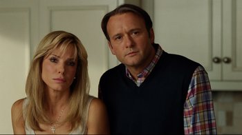 Movie still from “The Blind Side” (2009), directed by John Lee Hancock – A man and a woman standing next to each other in a room; Close Up shot, Over the shoulder angle