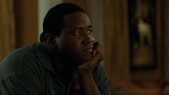 Movie still from “The Blind Side” (2009), directed by John Lee Hancock – A man sitting with his head resting on his hand; Close Up shot, Low angle