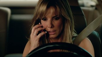 Movie still from “The Blind Side” (2009), directed by John Lee Hancock – A woman talking on a cell phone while sitting in a car; Close Up shot, High angle