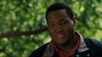 Movie still from “The Blind Side” (2009), directed by John Lee Hancock – A person smiling for the camera; Close Up shot, Over the shoulder angle