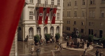 Movie still from “The Boy in the Striped Pajamas” (2008), directed by Mark Herman – A group of people standing around a building with nazi flags on it; Extreme Wide shot, High angle