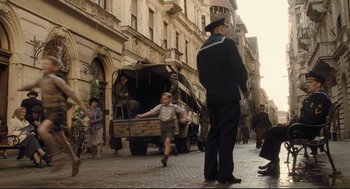 Movie still from “The Boy in the Striped Pajamas” (2008), directed by Mark Herman – A man and a boy are walking down the street; Wide shot, High angle