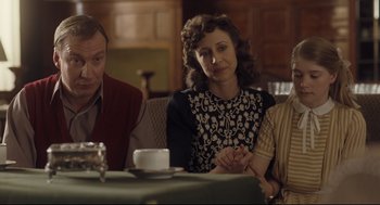 Movie still from “The Boy in the Striped Pajamas” (2008), directed by Mark Herman – A group of people sitting around a table; Medium shot, Over the shoulder angle