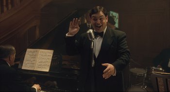 Movie still from “The Boy in the Striped Pajamas” (2008), directed by Mark Herman – A man in a tuxedo is singing into a microphone; Medium shot, Low angle