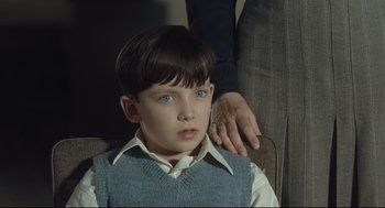 Movie still from “The Boy in the Striped Pajamas” (2008), directed by Mark Herman – A young boy sitting in front of an older person; Close Up shot, Over the shoulder angle