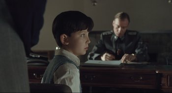 Movie still from “The Boy in the Striped Pajamas” (2008), directed by Mark Herman – A young boy sitting in front of an older man; Close Up shot, Over the shoulder angle