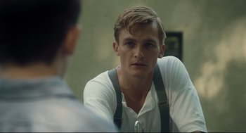 Movie still from “The Boy in the Striped Pajamas” (2008), directed by Mark Herman – A young man wearing suspenders looking at the camera; Close Up shot, Over the shoulder angle