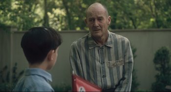 An older man talking to a young boy