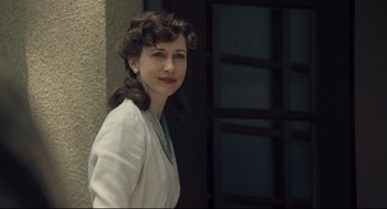 Movie still from “The Boy in the Striped Pajamas” (2008), directed by Mark Herman – A woman in a white dress standing in front of a building; Close Up shot, Over the shoulder angle