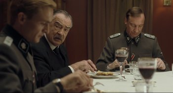 Movie still from “The Boy in the Striped Pajamas” (2008), directed by Mark Herman – A group of people sitting at a table with food on it; Medium shot, Over the shoulder angle